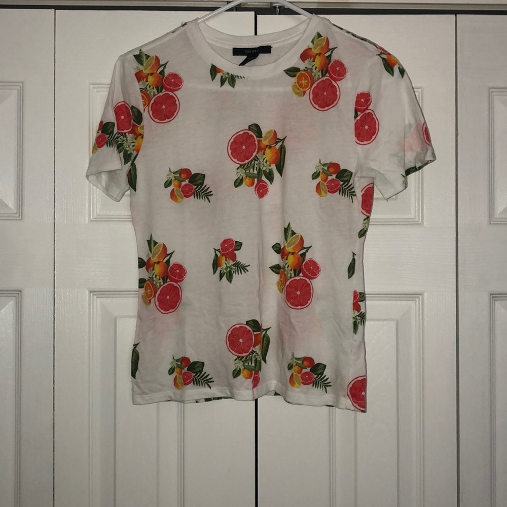 White t-shirt with oranges and pomegranates on it.